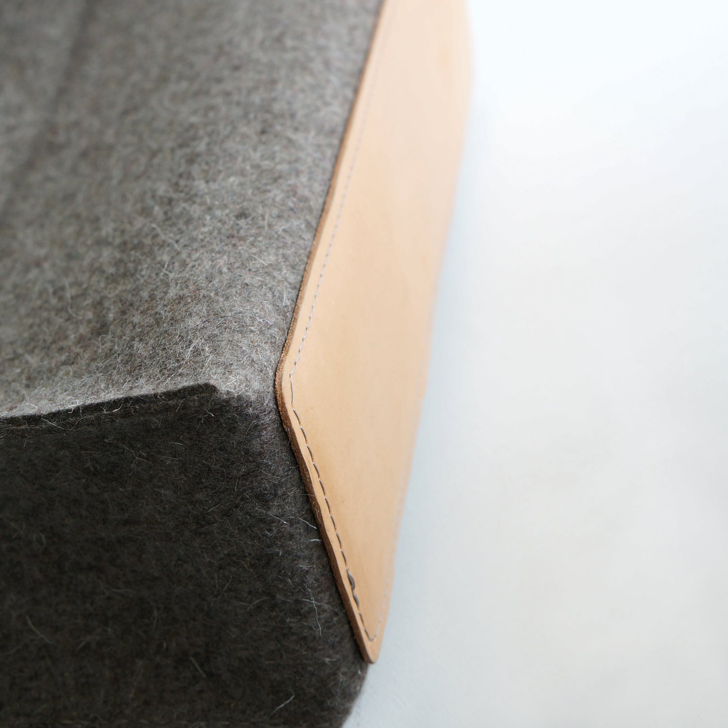 Taupe Oita rugzak van 3 mm wolvilt met leren handvatten en nikkelvoetjes onderkant